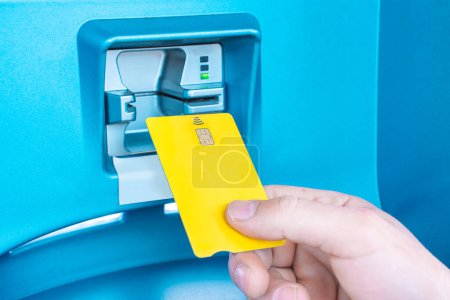 Photo for Hand Of a Person Putting Card In ATM. Image of an ATM Machine. High quality horizontal photo - Royalty Free Image