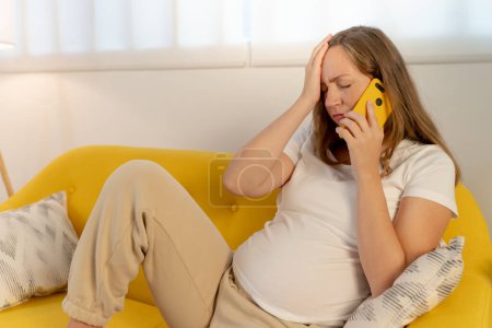Téléchargez les photos : Femme enceinte déprimée, stressée et fatiguée. Je passe un coup de fil avec le docteur. Photo de haute qualité - en image libre de droit