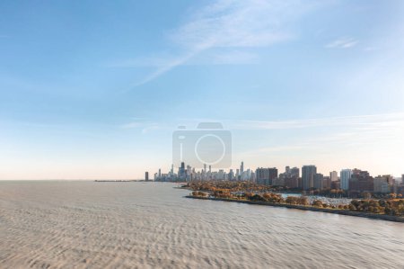 Foto de Aerial photograph of the Chicago skyline from over Lake Michigan with muddy colored water below and blue sky above on a sunny autumn day. - Imagen libre de derechos