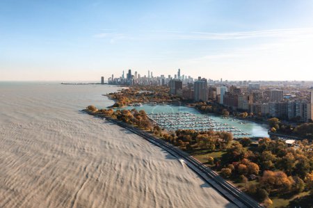 Foto de Aerial cityscape view above Lake Michigan overlooking Belmont harbor and the Lakeview neighborhood with the Chicago skyline in the distance on a sunny autumn day. - Imagen libre de derechos