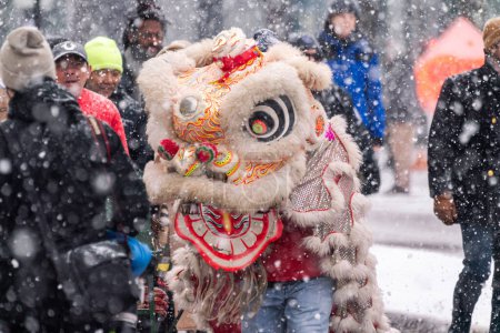 Téléchargez les photos : Chicago, IL - January 28th, 2023: Heavy snowfall comes down during the annual Argyle Lunar New Year parade as a lion dances to percussion music. - en image libre de droit