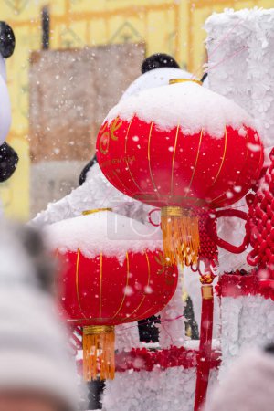 Foto de Chicago, IL - January 28th, 2023: Half snow covered decorative red and yellow Chinese lanterns hang off of a float during the annual Argyle Lunar New Year parade. - Imagen libre de derechos
