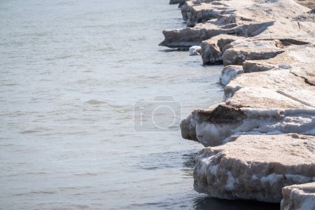 Foto de Fotografía del paisaje invernal de una costa irregular de nieve y hielo que se derrite a lo largo de las aguas del lago Michigan en Chicago. - Imagen libre de derechos