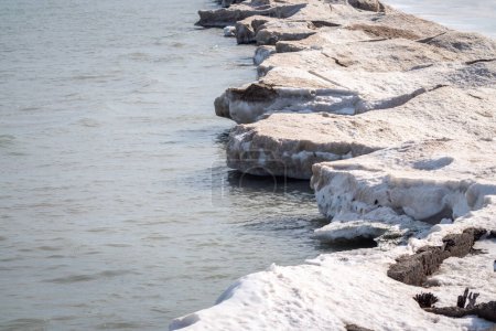 Photo for Winter landscape photograph of a jagged shoreline of melting snow and ice along the waters of Lake Michigan in Chicago. - Royalty Free Image