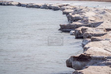 Photo for Winter landscape photograph of a jagged shoreline of melting snow and ice along the waters of Lake Michigan in Chicago. - Royalty Free Image
