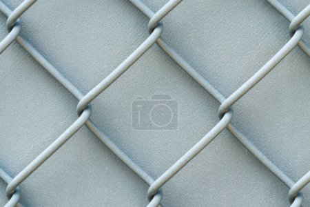 Photo for Closeup photograph of an old painted white and silver colored chainlink fence with crackled textured wind screen or tarp backdrop making a great background image. - Royalty Free Image