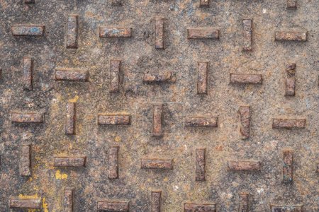 Photo for Close up photograph of an old vintage steel manhole cover with extremely weathered rusted and pitted orthogonal diamond plate relief pattern making a great industrial background. - Royalty Free Image