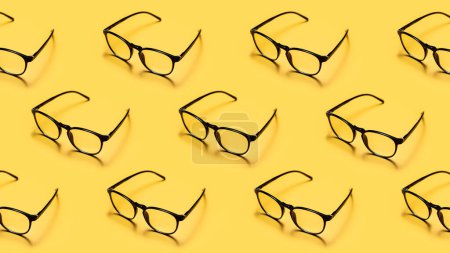 Téléchargez les photos : Lunettes de lecture modernes à monture noire ou lunettes répétées sur un fond jaune vif avec un style minimaliste. - en image libre de droit