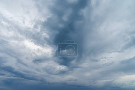 Photo for Close up photograph of turbulent looking storm clouds moving in the sky at sunset with dark blue shadows and texture isolated for sky replacement. - Royalty Free Image