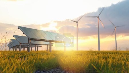 Foto de Concepto de energía renovable - energía fotovoltaica y aerogeneradores en una hierba archivada al atardecer - Imagen libre de derechos