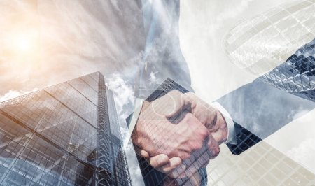 businessman partnership handshake concept. Skyscraper office building on Double exposure background
