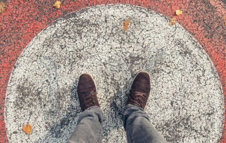 Photo for Young man in sneakers stands in a circle at the streets, personal pespective from above. - Royalty Free Image