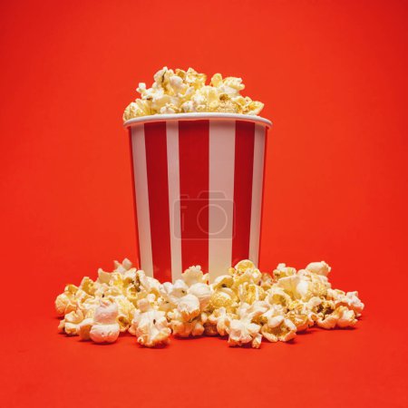 Photo for Popcorn in a box around on a bright red background - Royalty Free Image