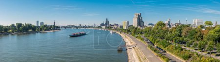 Köln-Panorama mit Dom, Booten, Rhein und Brücke an einem sonnigen Tag