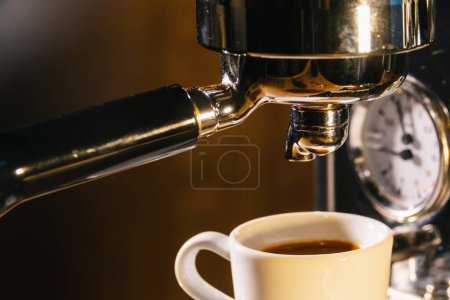 café expreso que vierte de la máquina de café en una taza. Imagen del concepto de elaboración de café profesional