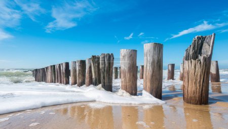 Rompeolas en olas en la playa en el mar del norte en Domburg Holanda