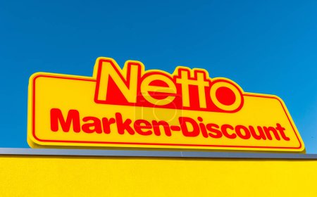 Téléchargez les photos : AACHEN, ALLEMAGNE FÉVRIER 2017 : Netto discount store Logo contre ciel bleu. Il fait partie du groupe Edeka, la plus grande société de supermarchés allemande employant 250 000 personnes.. - en image libre de droit