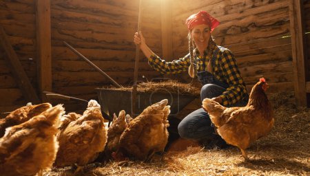 Photo for Proud chicken farmer woman guarding her hens in a henhouse - Royalty Free Image
