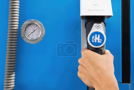 Photo for Aachen, Germany, January 2021: Female hold a fuel dispenser with - Royalty Free Image