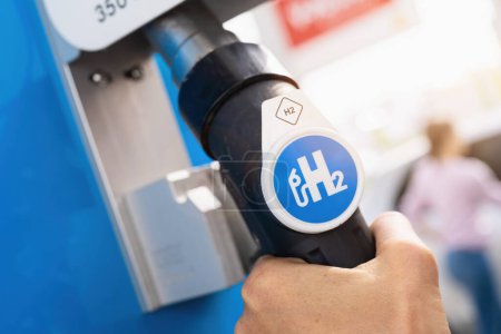 Photo for Aachen, Germany, January 2021: Female hold a fuel dispenser with hydrogen on gas station. h2 combustion engine for emission free eco friendly transport. - Royalty Free Image
