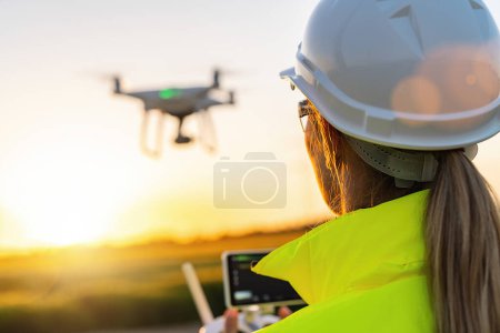 Téléchargez les photos : Inspection des drones. Exploitant femelle inspectant éolienne avec drone. concept d'énergie renouvelable - en image libre de droit