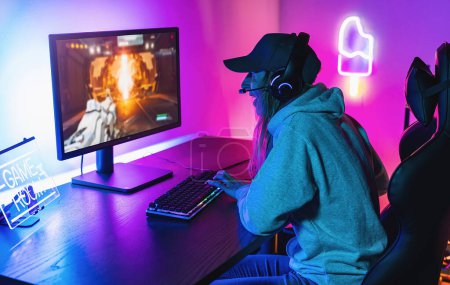 Photo for Professional eSport female Gamer Playing in Competitive Strategy Video Game on a Cyber Games Tournament at home. Talk to Each other into Microphones. Arena Looks Cool with Neon Lights - Royalty Free Image