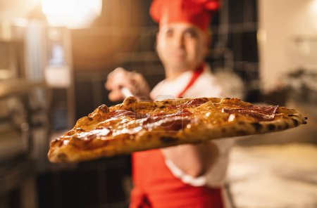 Foto de Panadero tradicional celebración de pizza en la cáscara en la pizzería italiana - Imagen libre de derechos