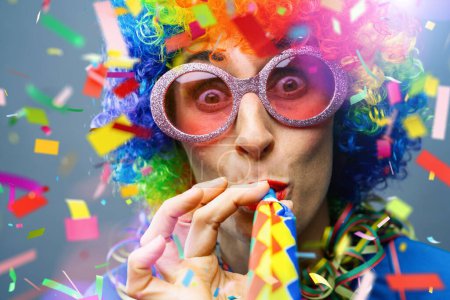 Foto de Feliz fiesta mujer con peluca y confeti piezas y cinta cayendo en colores coloridos - Imagen libre de derechos