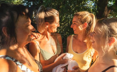 Foto de Grupo de mujeres envueltas en toallas después de una sauna finlandesa, charlando felizmente - Imagen libre de derechos