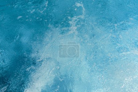Agua de la piscina azul con reflejos de luz y suaves ondas en un hotel spa