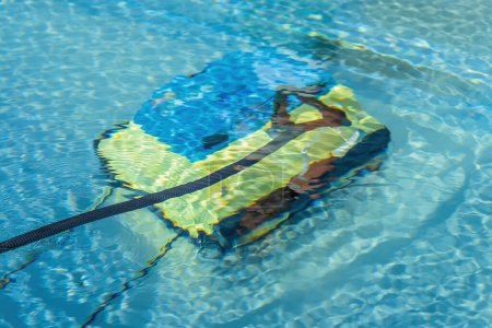 Limpieza del suelo de la piscina con una aspiradora subacuática, concepto de mantenimiento de la piscina.