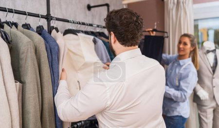 Tailor advising a man on selecting a matching suit jacket for his pants