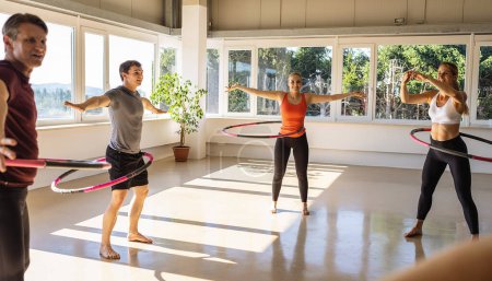 Photo for Team Sport group of people doing hula hoop in step waist hooping forward stance in fitness gym for healthy lifestyle concept. - Royalty Free Image