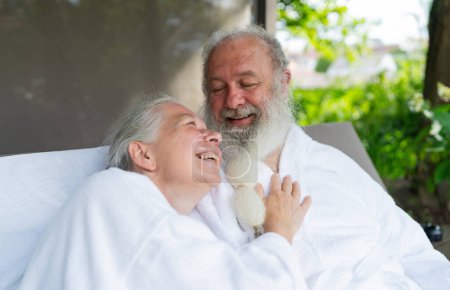 Verliebte Senioren betrachten einander entspannt auf der Liege im Wellness-Spa-Resort. Senior Moments Konzeptbild