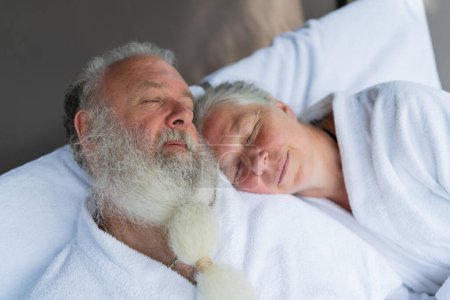 Schlafendes Senioren-Paar entspannt zusammen auf Liegestühlen im Wellness-Spa-Resort. Senior Moments Konzeptbild