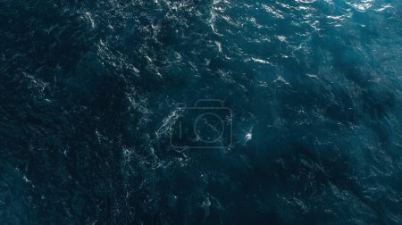 Vista aérea del océano azul oscuro con patrones de agua texturizados y reflejos de luz. Drobe Shot