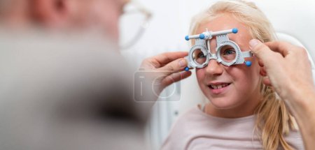 Junges Mädchen lässt sich mit optischer Messbrille vom Augenoptiker testen.