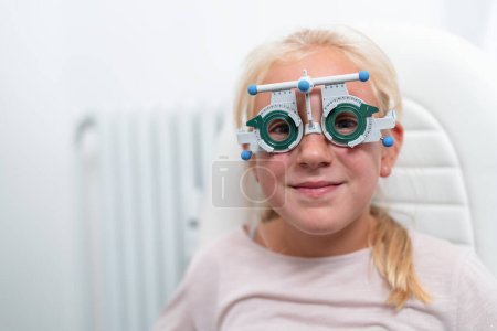 Foto de Chica joven con gafas de prueba durante una prueba de optometría - Imagen libre de derechos