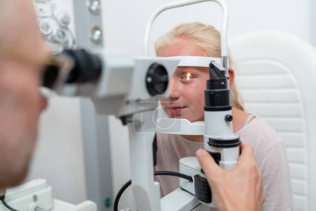 Foto de Primer plano de una chica revisando la visión con tonómetro en la clínica ocular - Imagen libre de derechos