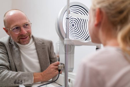 Optometrist conducting a vision test to a child with a keratograph or phoropter at the ophthalmology clinic. Close-up photo. Healthcare and medicine concept