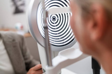 Foto de Primer plano de un paciente sometido a un examen ocular con un queratógrafo o foroptero en una clínica. - Imagen libre de derechos