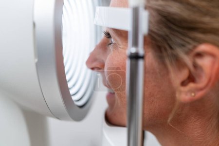 Primer plano de un paciente sometido a un examen ocular con un queratograma o foroptero en la clínica de oftalmología. Fotografía de cerca. Concepto de salud y medicina