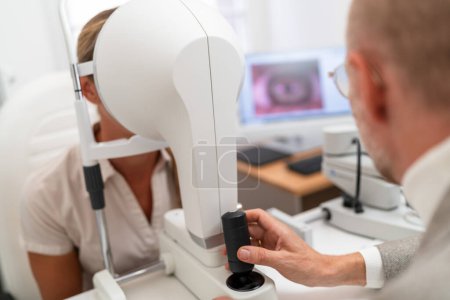 Optometrist administering with Keratograph an eye test to a female patient at the ophthalmology clinic. Close-up photo. Healthcare and medicine concept