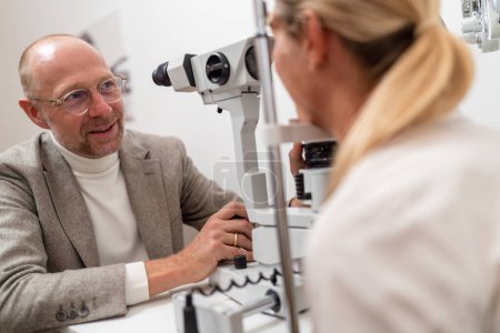 Man undergoing an eye examination using a slit lamp at the clinic. Close-up photo. Healthcare and medicine concept