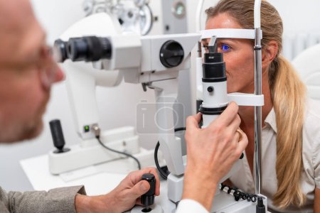 Nahaufnahme einer Augenuntersuchung mit einem Augenoptiker, der die Spaltlampe in der Augenklinik justiert. Nahaufnahme. Gesundheits- und Medizinkonzept