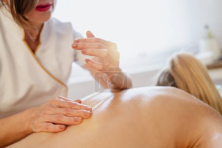 Close-up of a massage therapist's hands over a client's back, ready to massage. beauty salon Wellness Hotel Concept image