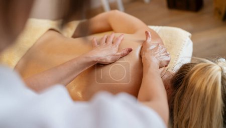 Draufsicht auf die Hände eines Massagetherapeuten auf dem Rücken eines Klienten während einer Sitzung. Schönheitssalon Wellness Hotel Konzept Bild