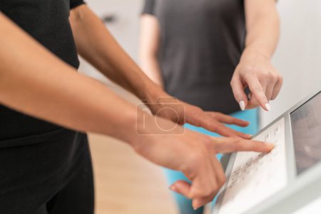 Die Hand einer Person zeigt die Funktion der Touchscreen-Schnittstelle einer Körperzusammensetzungswaage während eines Inbody-Tests in einem Fitnessstudio