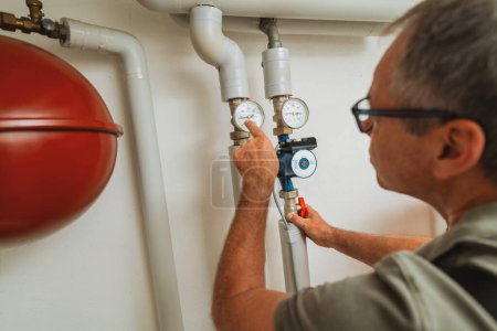 Heizungsingenieur überprüft Gasthermostat in Heizungsraum mit alter Gasheizung. Konzept zum Austausch von Gasheizungen
