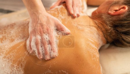 Photo for Woman having massage in hamam with foam in spa resort - Royalty Free Image